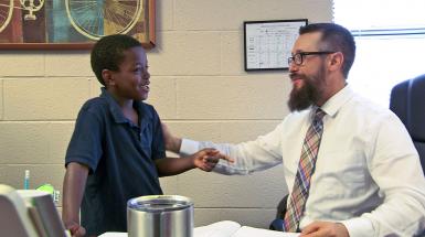 teacher speaking with young student